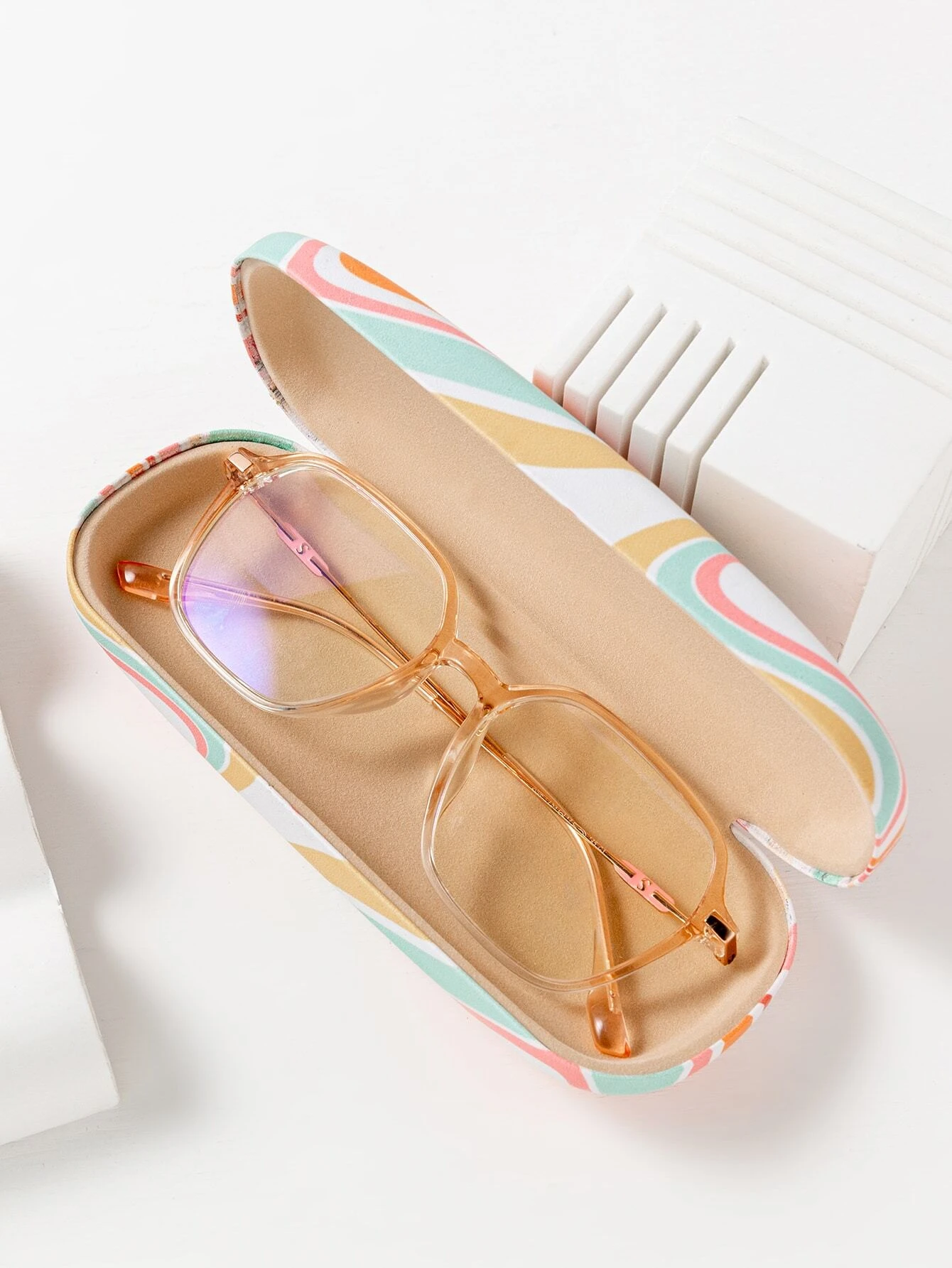 A glasses case with a color block print design. The case is designed to store and protect eyeglasses, sunglasses, or other optical frames. The color block pattern adds a modern and stylish touch to the case. This accessory is both functional and fashionable, offering a secure and trendy storage solution for eyewear.