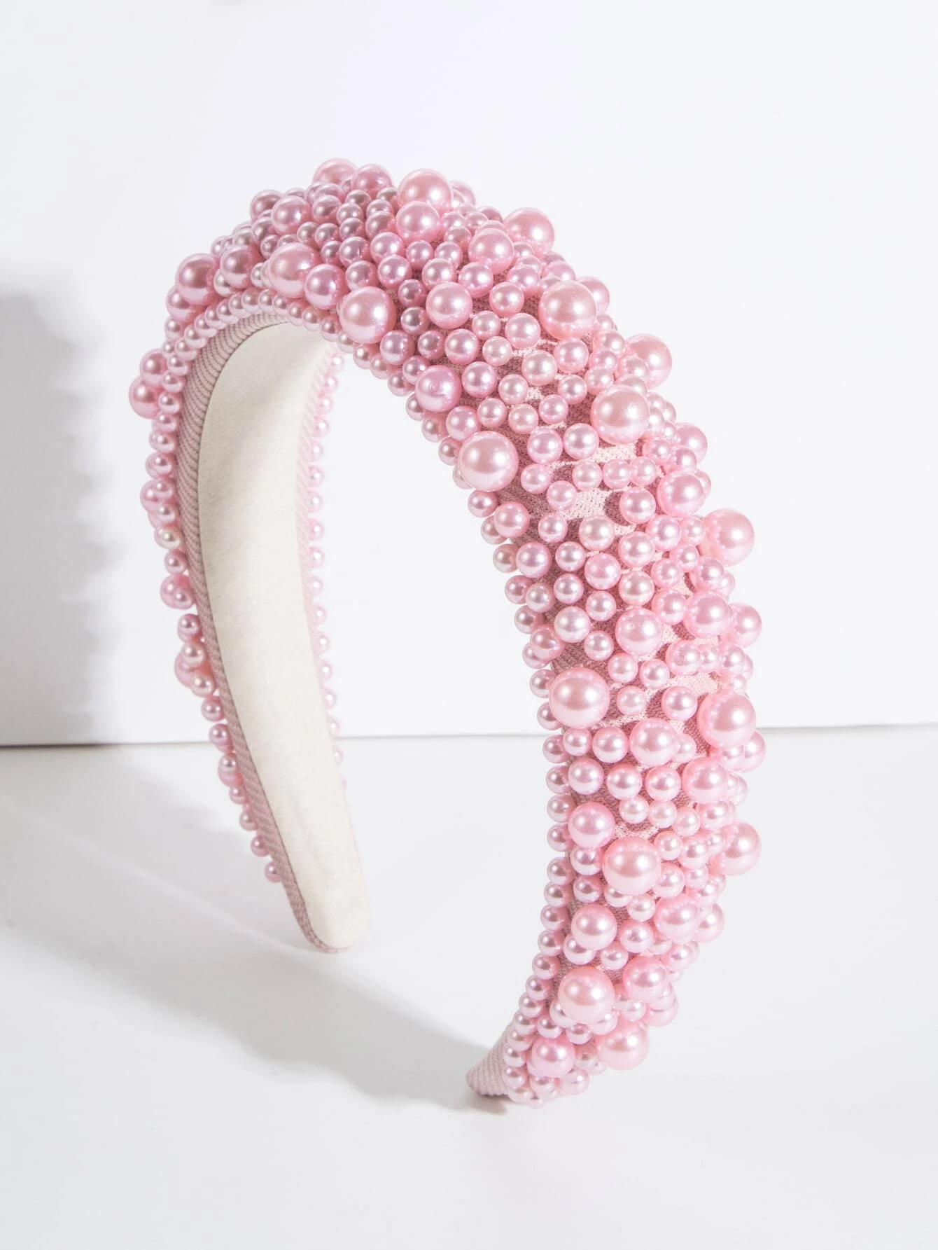 Wide headband adorned with faux pink pearls, offering a blend of style and sophistication, perfect for enhancing your hair ensemble.