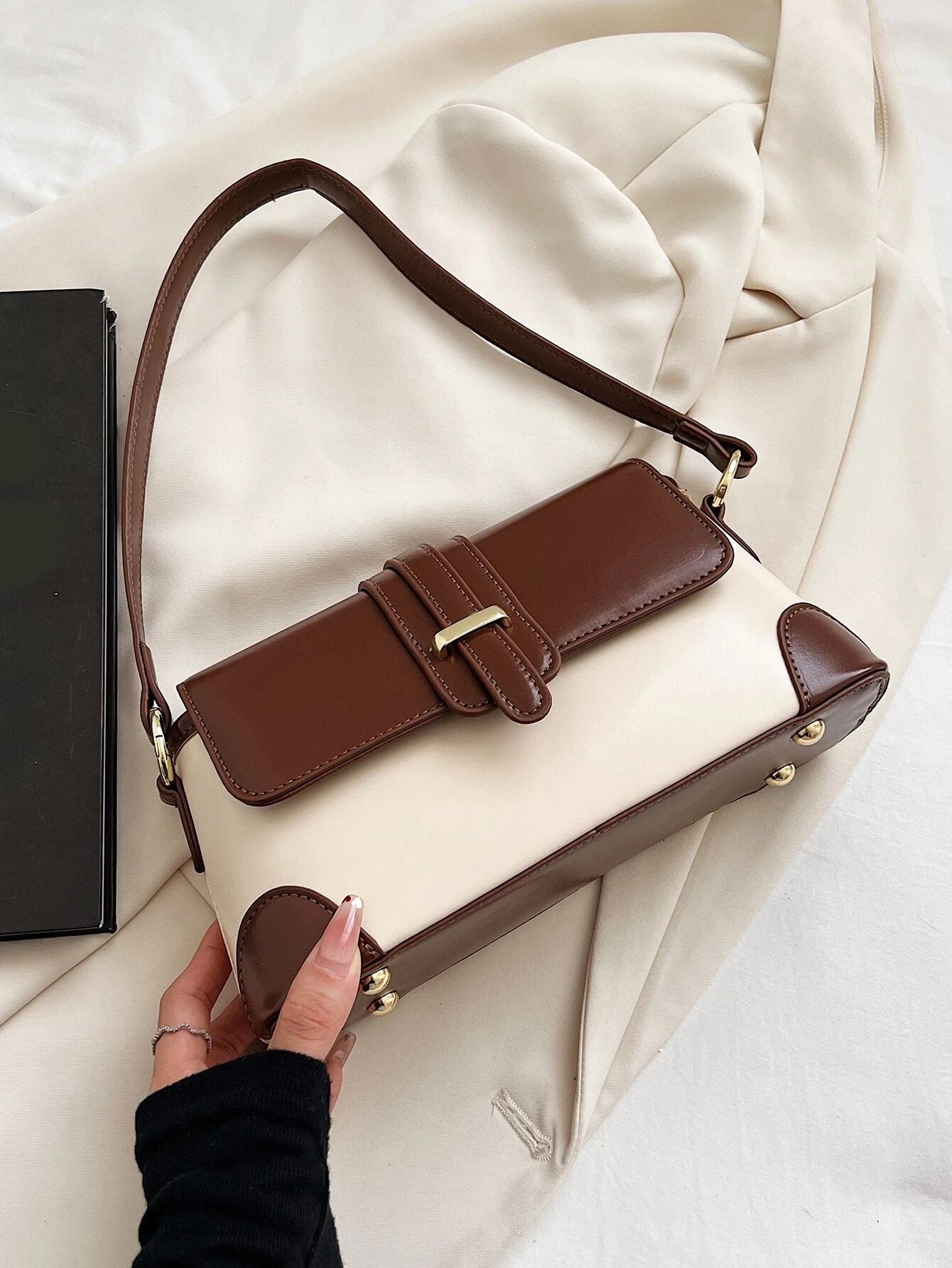 Square bag with colorblock flap design. This accessory boasts a modern and dynamic look, featuring contrasting color panels that add visual interest and style to your ensemble.