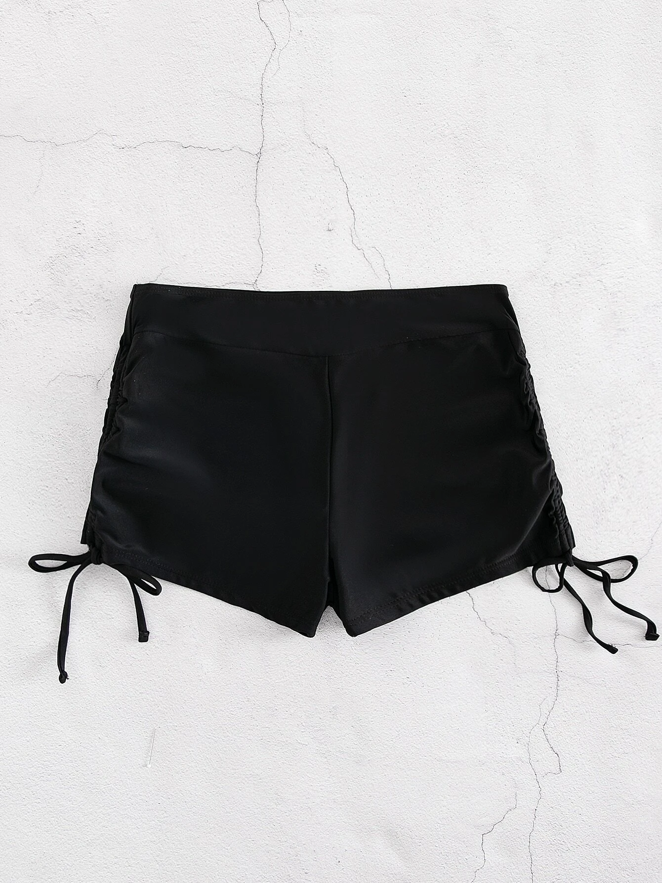 Bikini shorts with drawstring sides for adjustable fit. These shorts feature a versatile design with adjustable drawstring sides, allowing for a customizable and comfortable fit. The shorts are ideal for beach or pool activities and offer a trendy and practical swimwear option. The drawstring detail adds a touch of style while ensuring a secure and personalized fit, making these shorts a fashionable choice for any water-related outing.