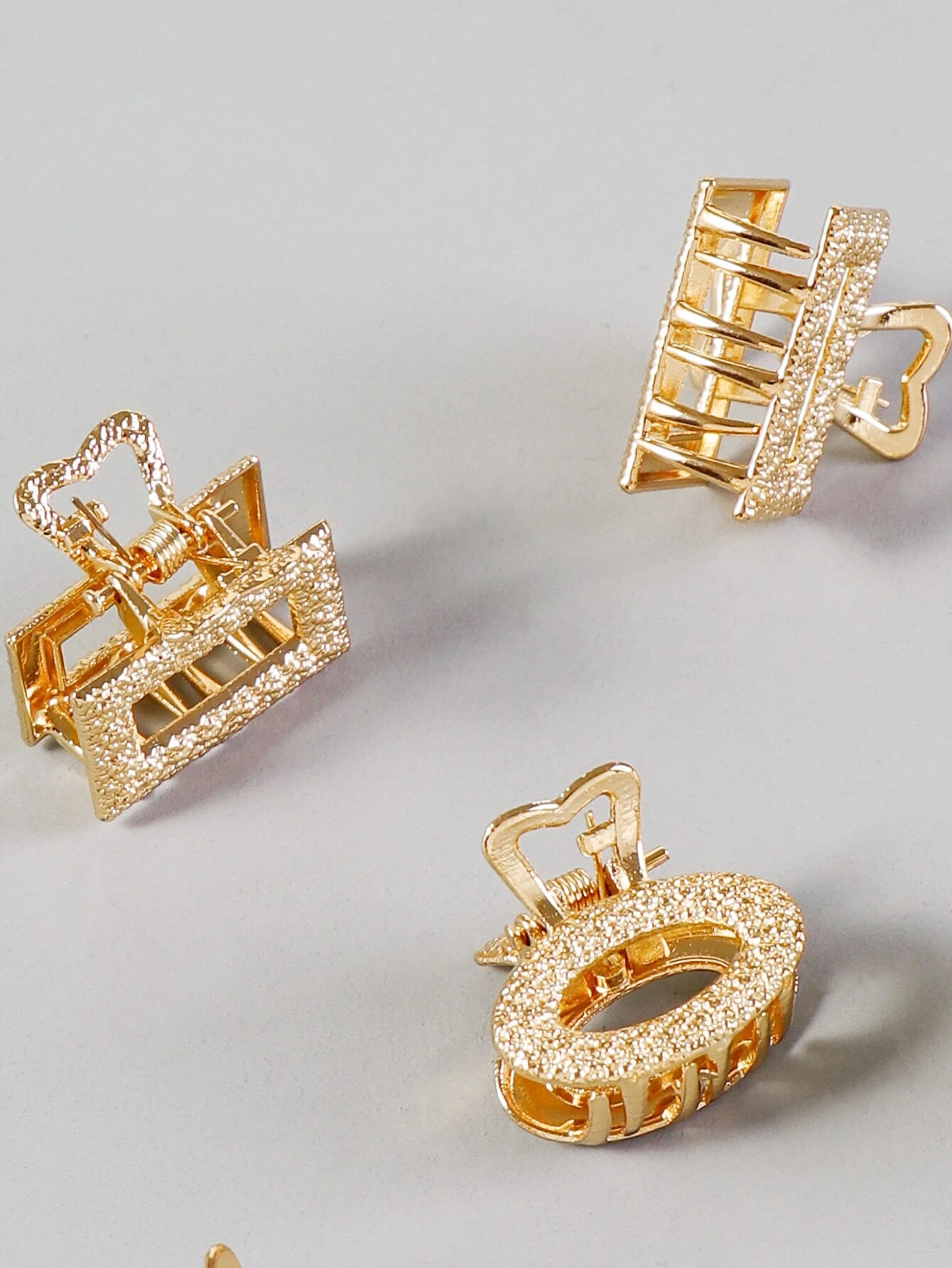 A set of six metallic hair claws, providing a sleek and modern way to secure and style your hair with a touch of shine.