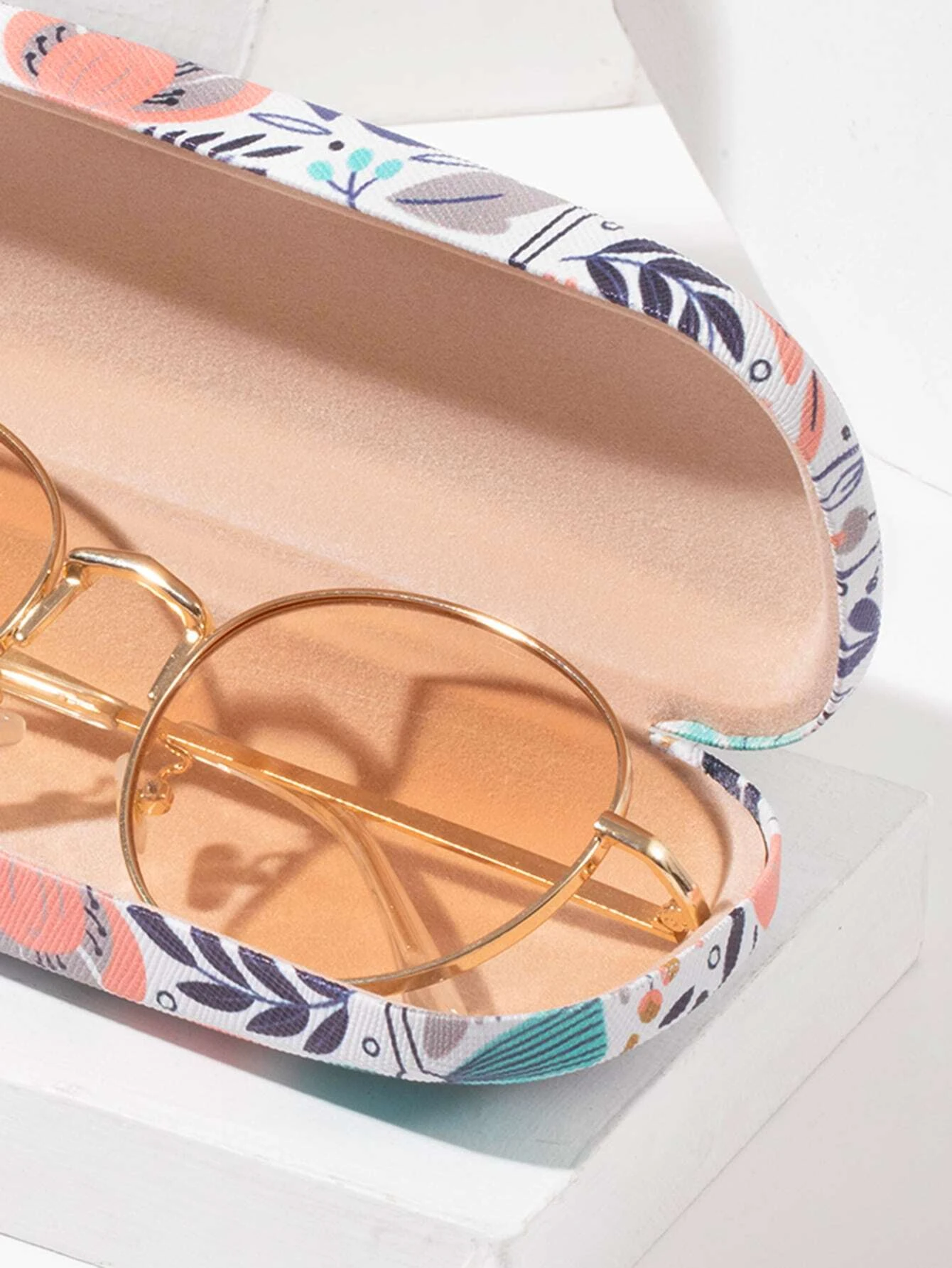 A glasses case featuring a floral print design. The case is designed to store and protect eyeglasses, sunglasses, or other optical frames. The floral print adds a touch of elegance and style to the case. This accessory is both functional and fashionable, offering a secure and stylish storage solution for eyewear.