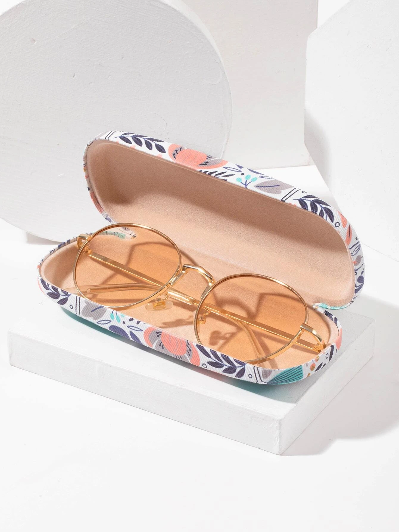 A glasses case featuring a floral print design. The case is designed to store and protect eyeglasses, sunglasses, or other optical frames. The floral print adds a touch of elegance and style to the case. This accessory is both functional and fashionable, offering a secure and stylish storage solution for eyewear.