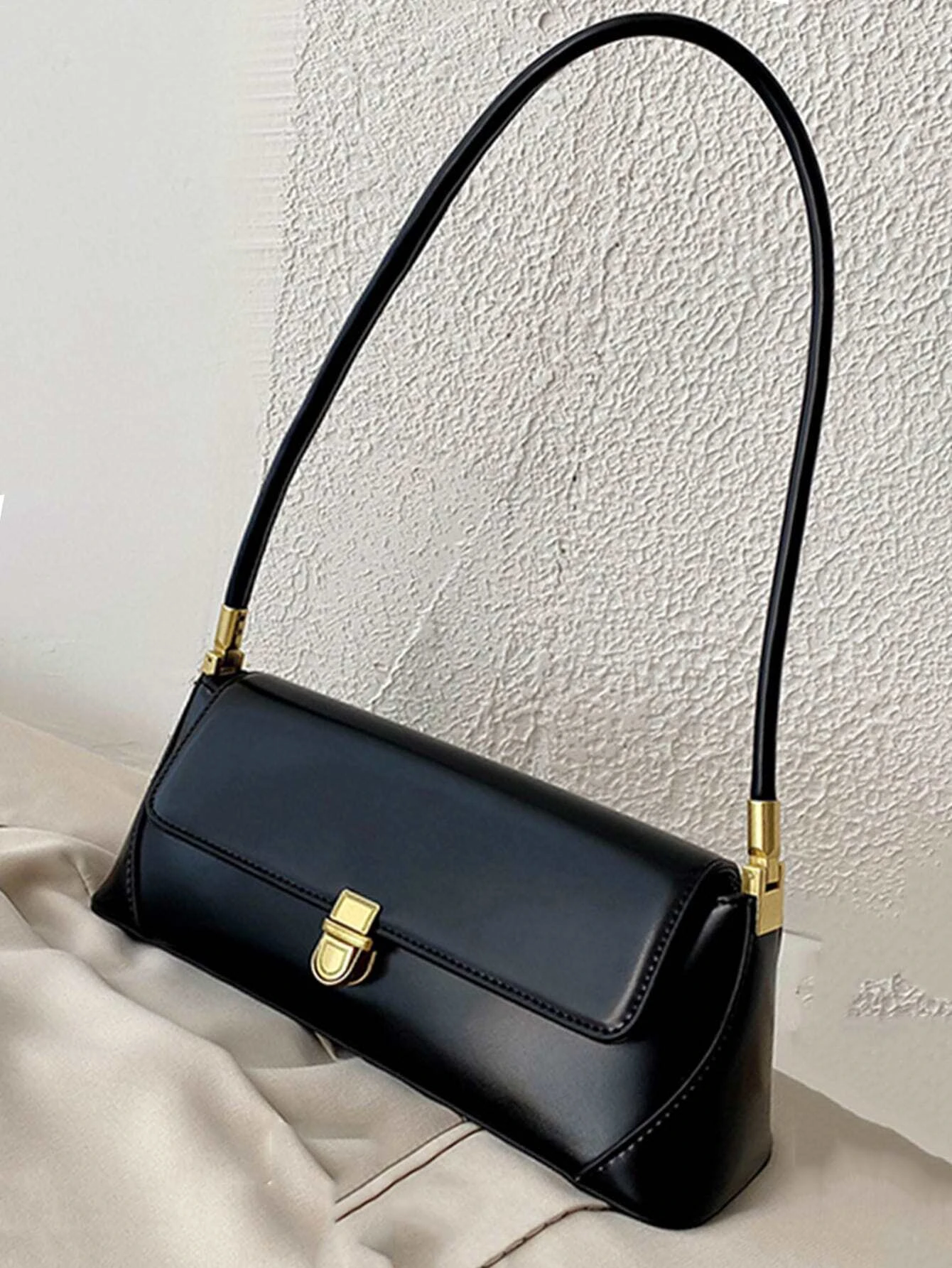 Flap baguette bag with minimalist design. This accessory offers a sleek and stylish way to carry your essentials, embodying modern elegance and functionality.