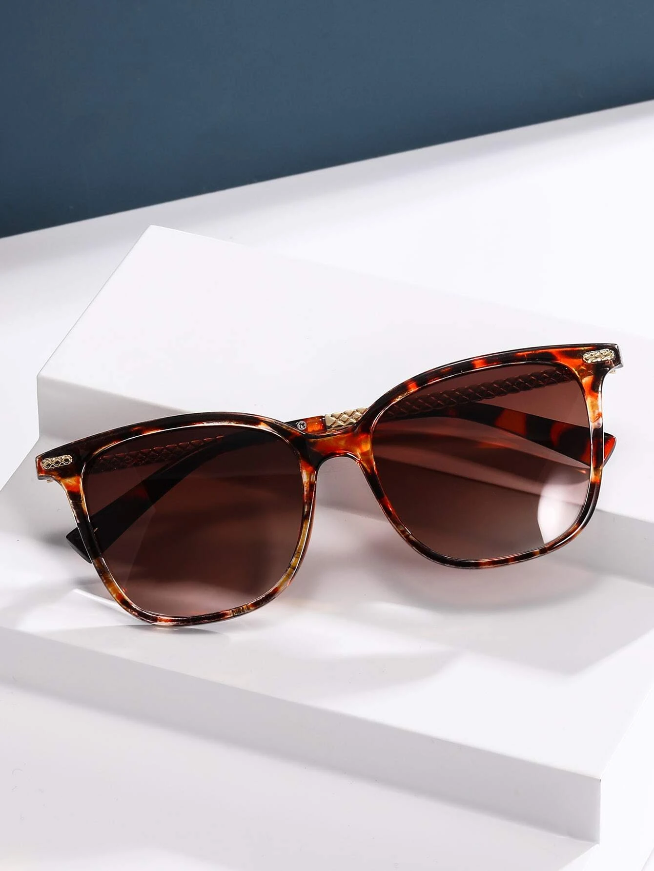 Stylish tortoiseshell frame sunglasses featuring a mottled pattern of rich browns and ambers. The oversized round lenses provide UV protection and a touch of vintage flair, while the sturdy frame design ensures both comfort and durability.