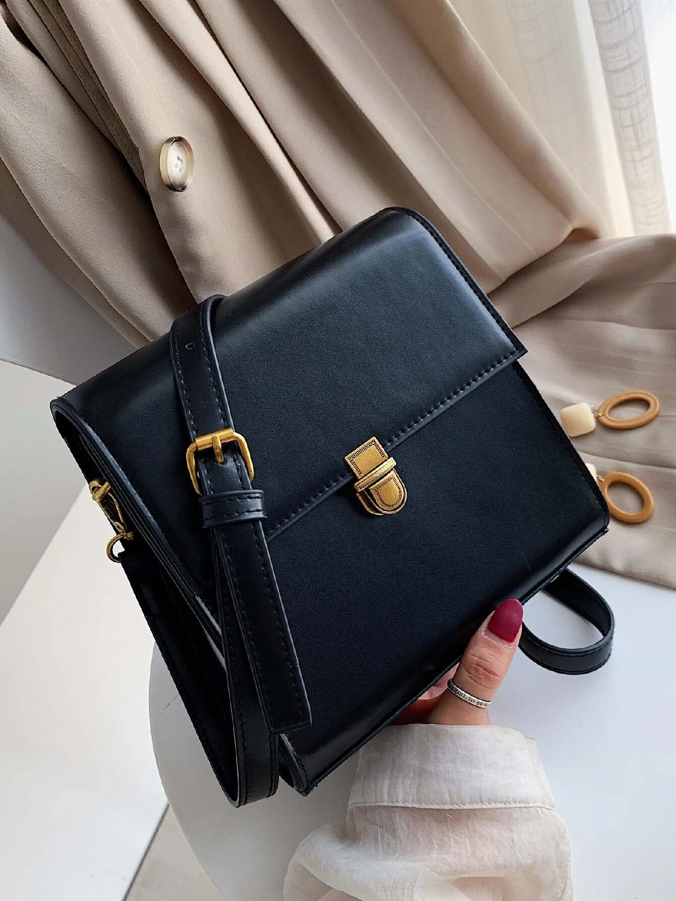 Mini square bag with minimalist design and snap button detail flap. This accessory combines simple elegance with functional embellishments, offering a chic and versatile way to carry your essentials.