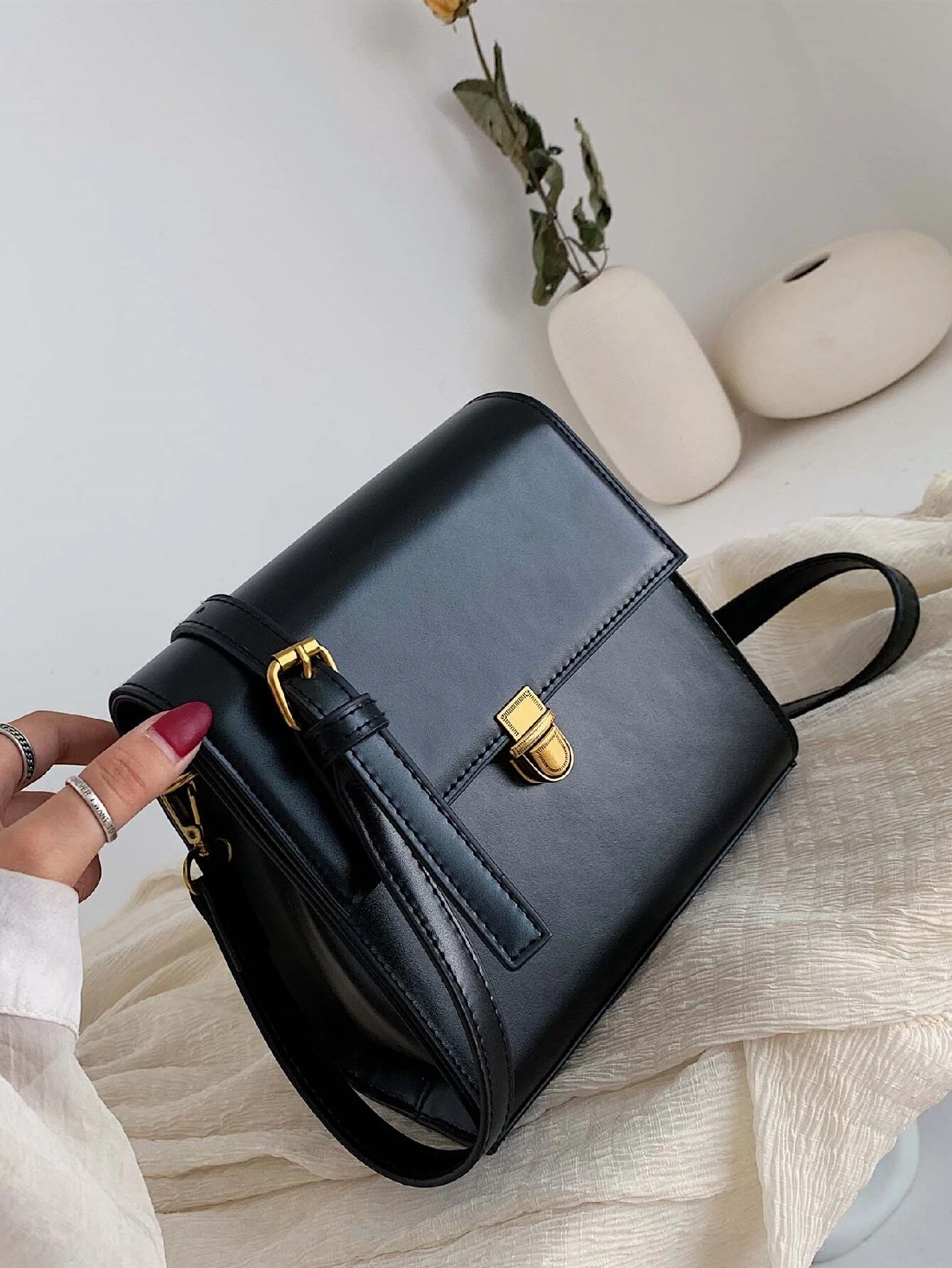 Mini square bag with minimalist design and snap button detail flap. This accessory combines simple elegance with functional embellishments, offering a chic and versatile way to carry your essentials.