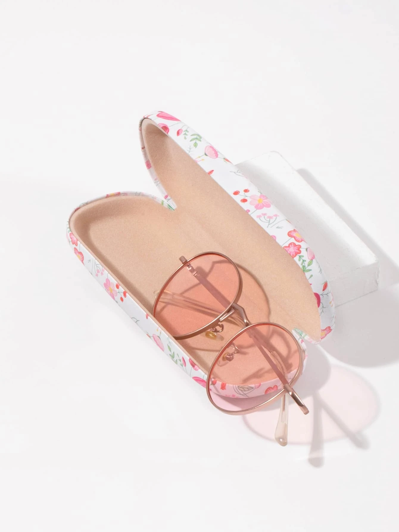 A glasses case featuring a floral print design. The case is designed to store and protect eyeglasses, sunglasses, or other optical frames. The floral print adds a touch of elegance and style to the case. This accessory is both functional and fashionable, offering a secure and stylish storage solution for eyewear.