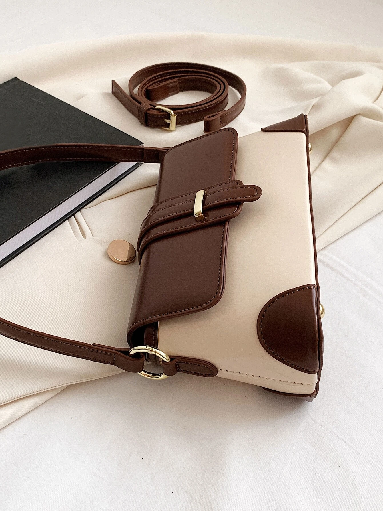 Square bag with colorblock flap design. This accessory boasts a modern and dynamic look, featuring contrasting color panels that add visual interest and style to your ensemble.