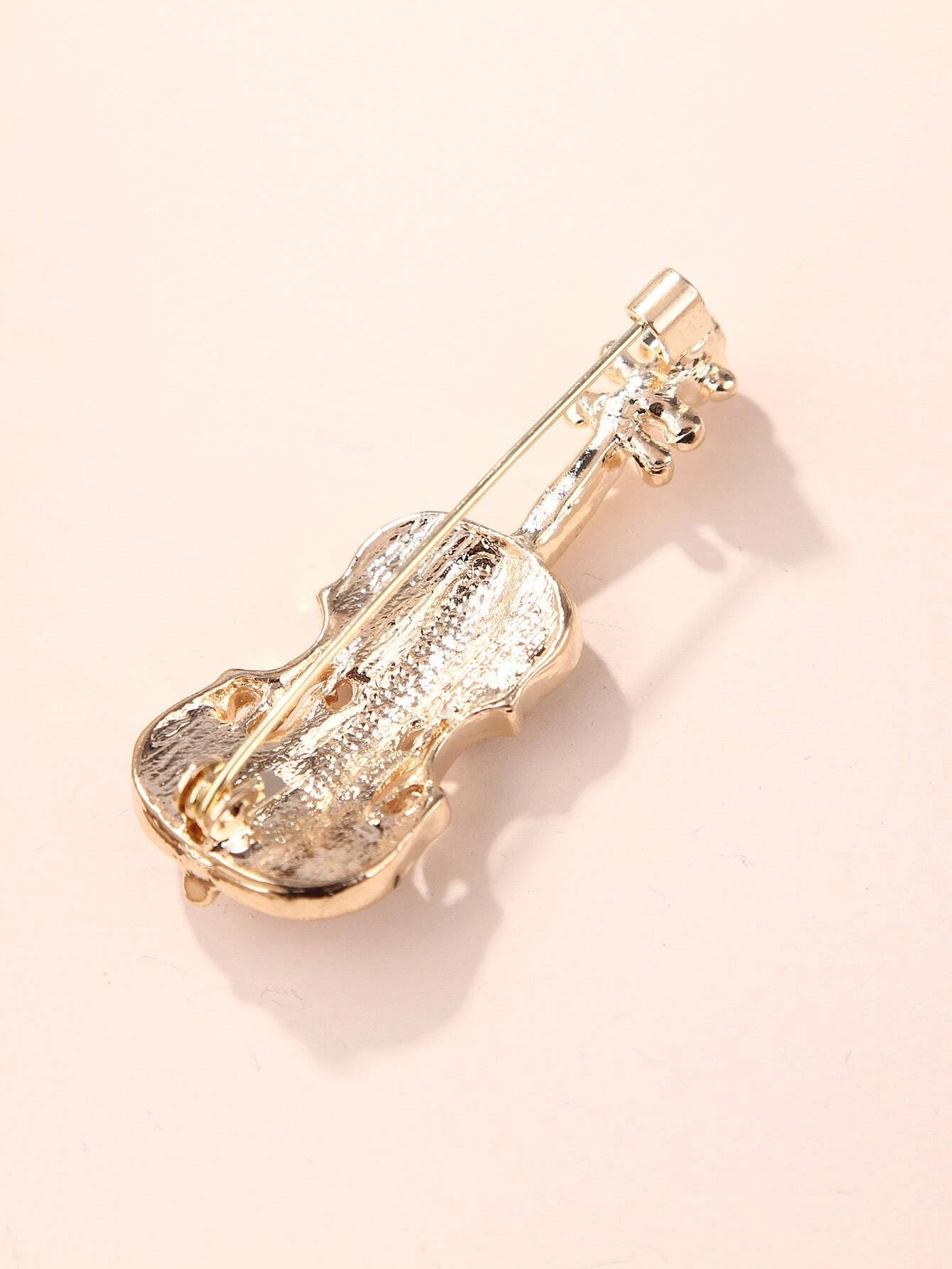 Brooch featuring a violin design, adorned with shimmering rhinestones, capturing the elegance and beauty of music in a glamorous and artistic accessory.